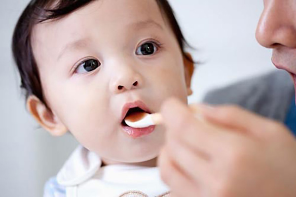 BÁC SĨ ĐANG CẦM LỌ THUỐC KHÁNG SINH VÀ GIẢI THÍCH LIỀU DÙNG CHO MẸ CỦA BÉ