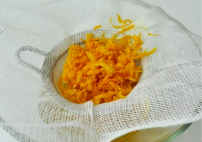 Cách làm tinh dầu cam: Dùng vải xô để vắt tinh dầu